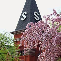 Old Main steeple with spring colored flowers on trees